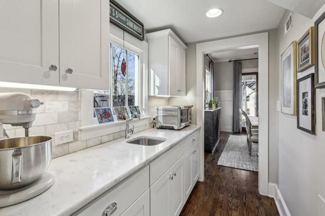 kitchen featuring dark wood-style floors, visible vents, a toaster, a sink, and white cabinetry