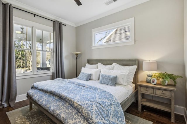 bedroom with crown molding, wood finished floors, visible vents, and baseboards