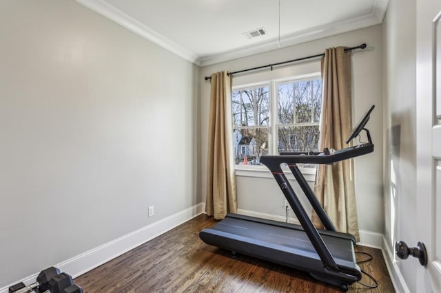 exercise room featuring baseboards, visible vents, dark wood-style flooring, and ornamental molding