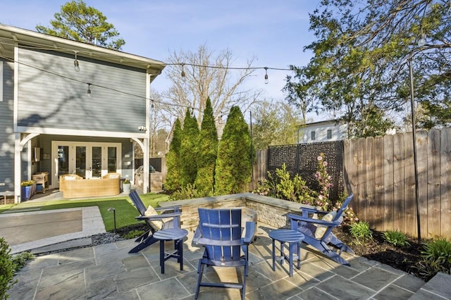 view of patio with an outdoor living space, french doors, and a fenced backyard