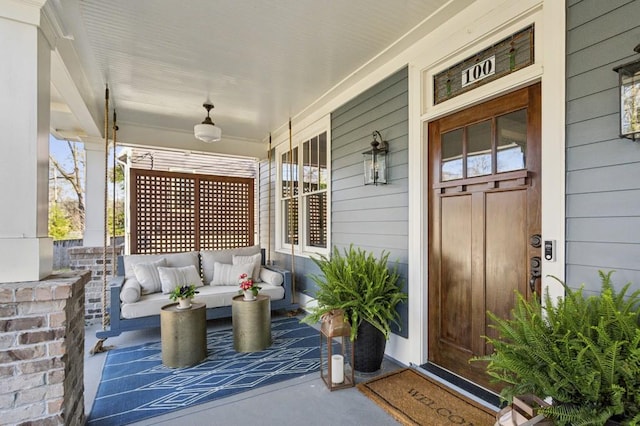 entrance to property with a porch and an outdoor hangout area