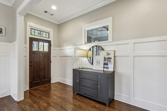 entryway with visible vents, ornamental molding, dark wood-style flooring, and a decorative wall