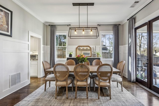 dining space with ornamental molding, visible vents, and wainscoting