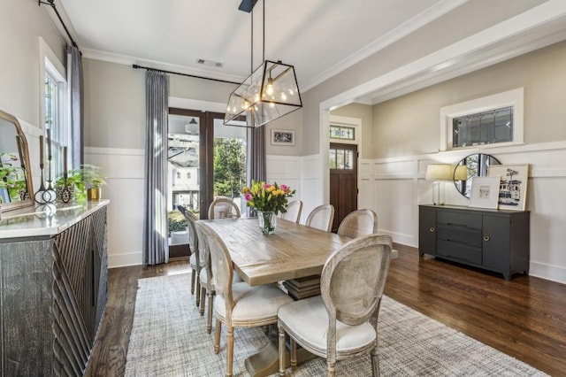 dining area with ornamental molding, wood finished floors, visible vents, and wainscoting