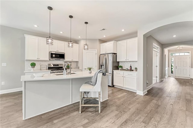 242 Aspen Way, Dallas, GA 30157 - kitchen with appliances with stainless steel finishes, arched walkways, light wood-type flooring, tasteful backsplash, and recessed lighting