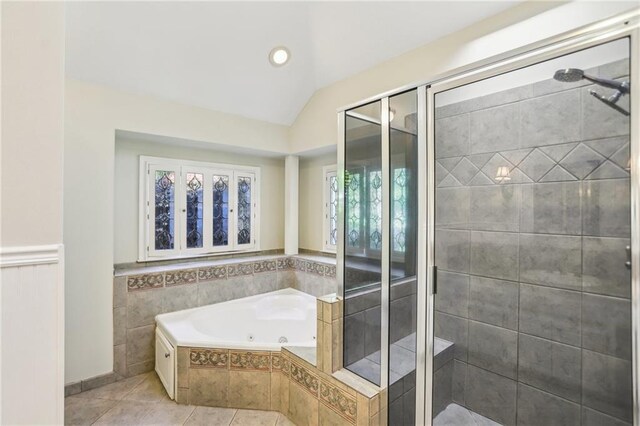 full bathroom with a stall shower, tile patterned flooring, a tub with jets, lofted ceiling, and wainscoting