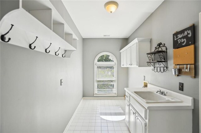 mudroom featuring a sink, baseboards, and light tile patterned flooring