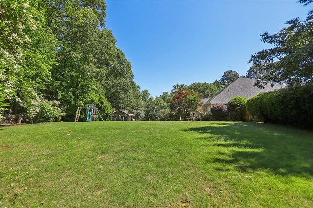 view of grassy yard with a playground