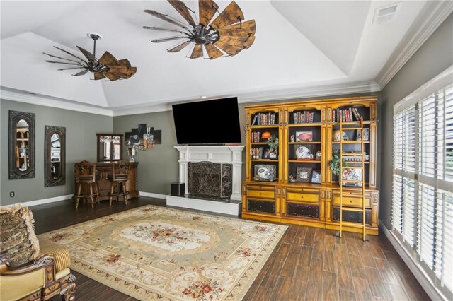 living area featuring lofted ceiling, ceiling fan, dark wood finished floors, a fireplace with raised hearth, and baseboards