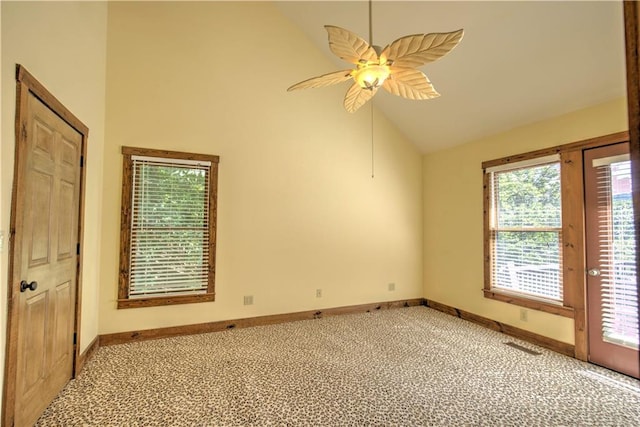 carpeted empty room featuring ceiling fan, high vaulted ceiling, and baseboards