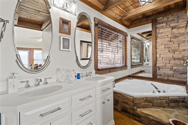 full bath with beam ceiling, a garden tub, wood ceiling, and a sink