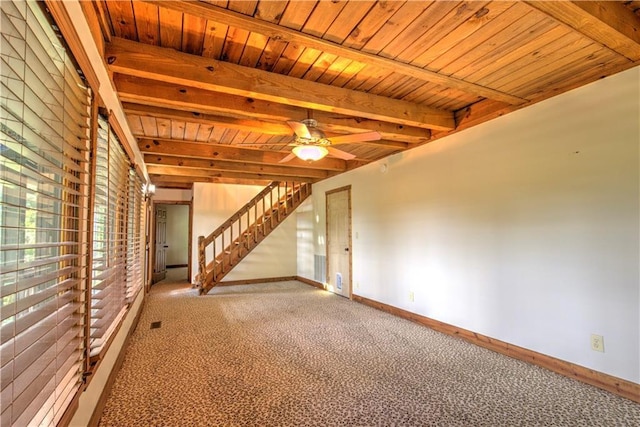 unfurnished living room with baseboards, beam ceiling, wood ceiling, and carpet flooring