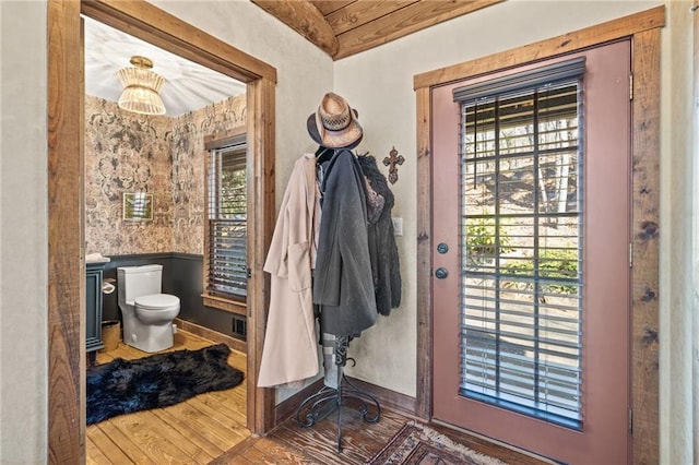 interior space with a wainscoted wall, visible vents, and wood finished floors