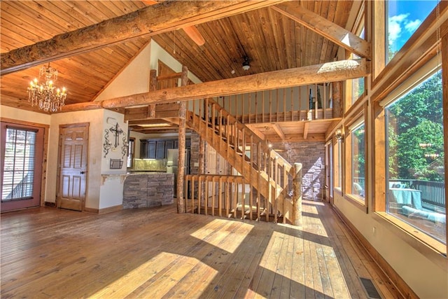 interior space with wood ceiling, plenty of natural light, a chandelier, and lofted ceiling with beams