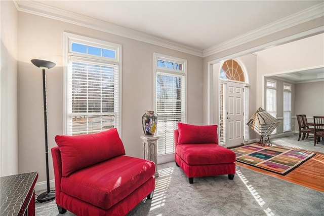 sitting room with carpet, a healthy amount of sunlight, and crown molding