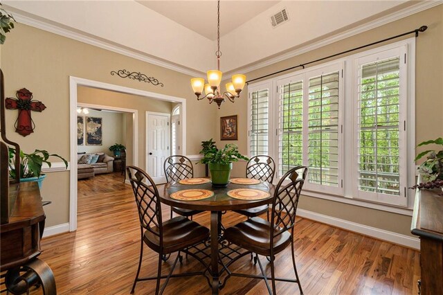 dining area featuring ornamental molding, a chandelier, and light hardwood / wood-style floors