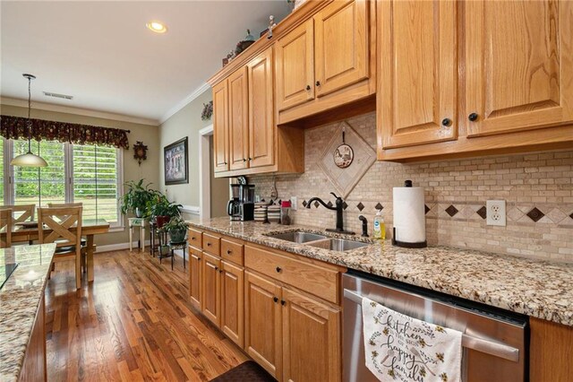 kitchen with hanging light fixtures, sink, stainless steel dishwasher, dark wood-type flooring, and crown molding