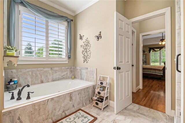 bathroom featuring ceiling fan, a relaxing tiled tub, crown molding, and hardwood / wood-style floors