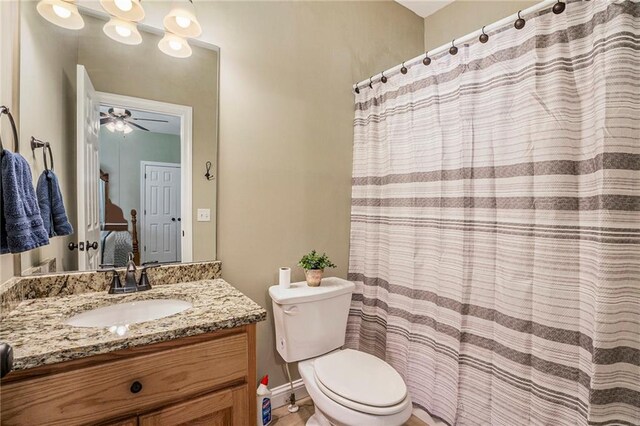 bathroom with walk in shower, vanity, toilet, and ceiling fan