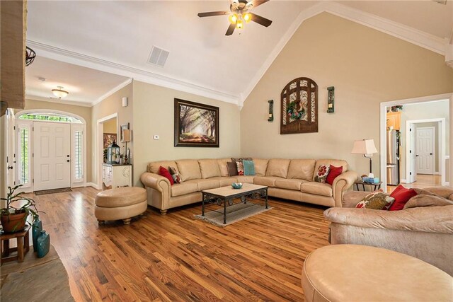 living room featuring ornamental molding, hardwood / wood-style floors, ceiling fan, and high vaulted ceiling