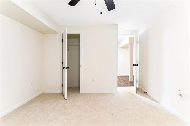 unfurnished bedroom featuring ceiling fan, light colored carpet, and a closet