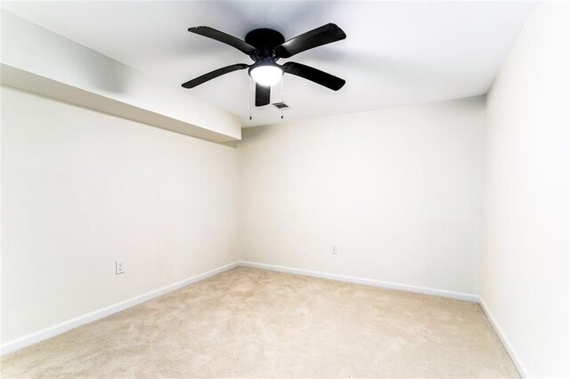 empty room featuring ceiling fan and light carpet