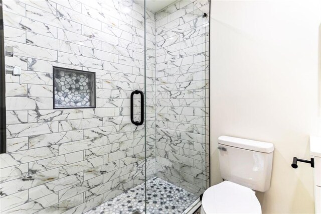 bathroom featuring walk in shower and toilet