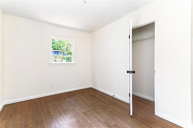 unfurnished bedroom with a closet and dark hardwood / wood-style floors