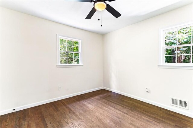 empty room with ceiling fan and dark hardwood / wood-style flooring