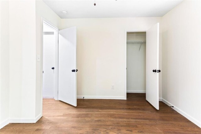 unfurnished bedroom featuring hardwood / wood-style flooring and a closet