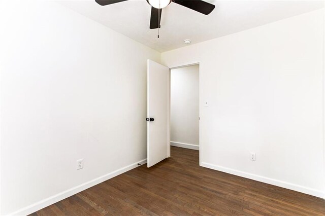 spare room featuring ceiling fan and dark wood-type flooring