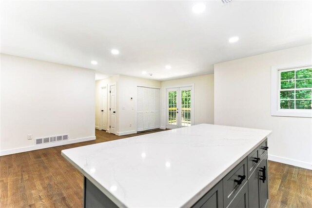 kitchen with gray cabinets, a center island, and dark hardwood / wood-style flooring