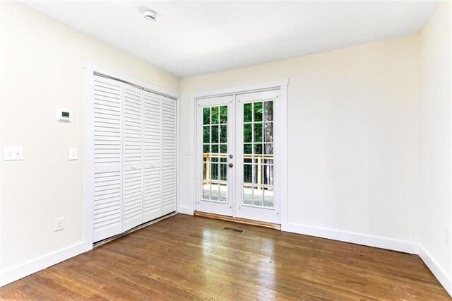 unfurnished room featuring french doors and dark hardwood / wood-style flooring