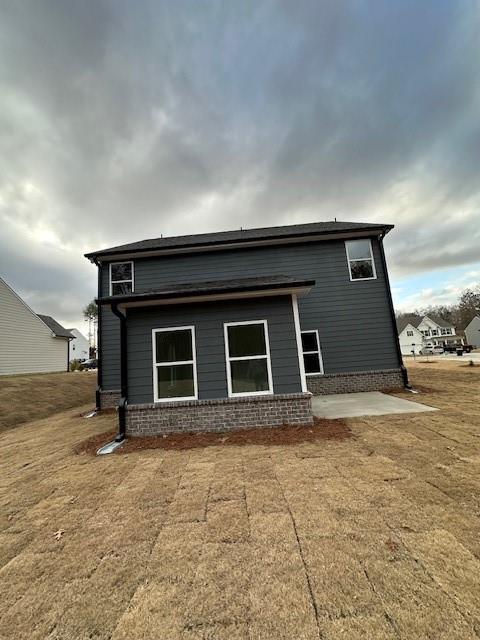 rear view of property featuring a lawn and a patio