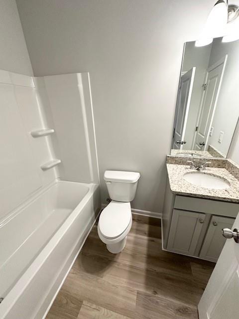 bathroom with toilet, baseboards, wood finished floors, and vanity