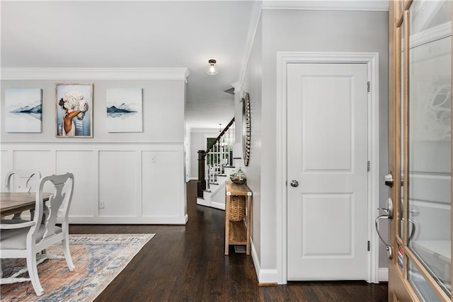 foyer entrance with crown molding and dark wood-type flooring