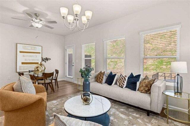1346 Riverstone Rd Unit 107, Jonesboro, GA 30238 - living room featuring wood finished floors, ceiling fan with notable chandelier, baseboards, and plenty of natural light