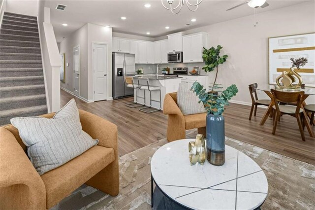 1346 Riverstone Rd Unit 107, Jonesboro, GA 30238 - living area featuring visible vents, baseboards, stairway, and light wood-style floors