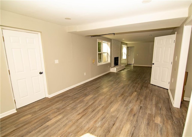 spare room featuring a fireplace and dark hardwood / wood-style floors