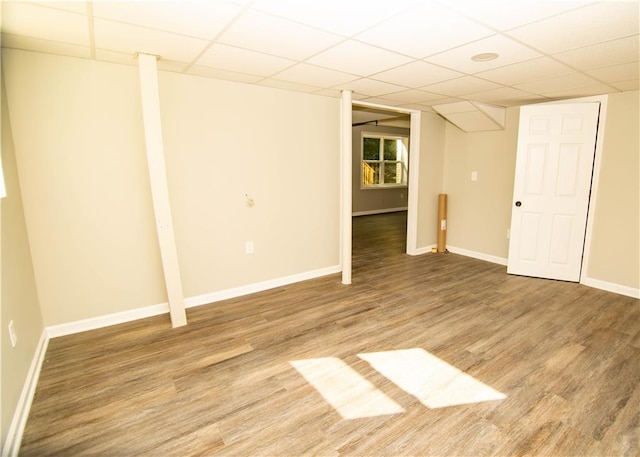 basement featuring a paneled ceiling and hardwood / wood-style floors