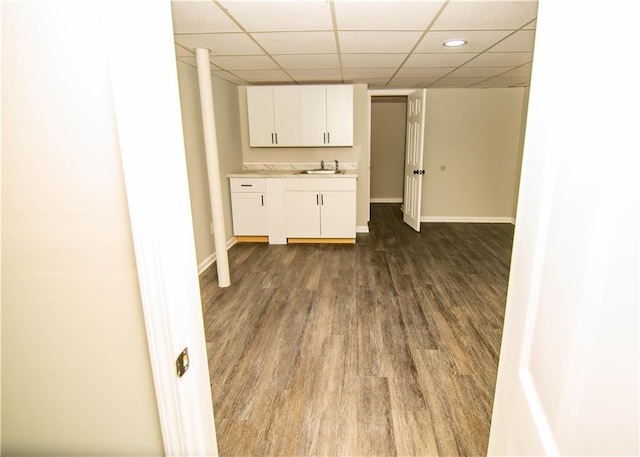 kitchen featuring a paneled ceiling, dark hardwood / wood-style floors, sink, and white cabinets