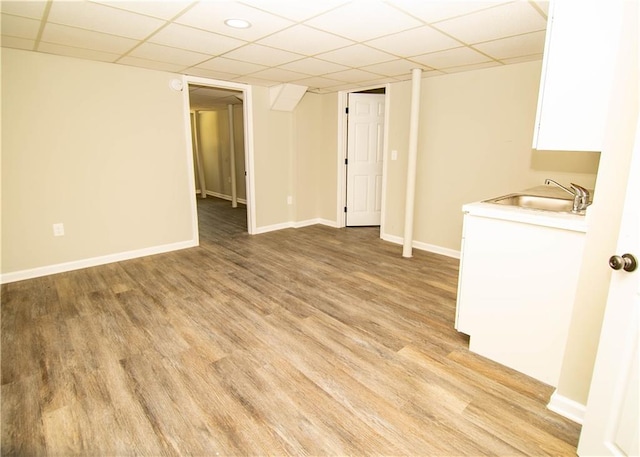 interior space featuring sink, light hardwood / wood-style flooring, and a drop ceiling