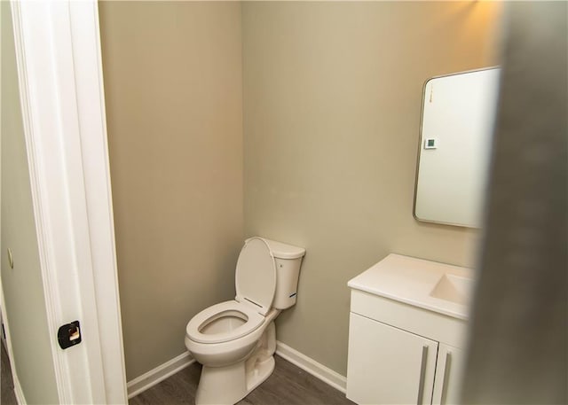 bathroom featuring vanity, toilet, and hardwood / wood-style floors