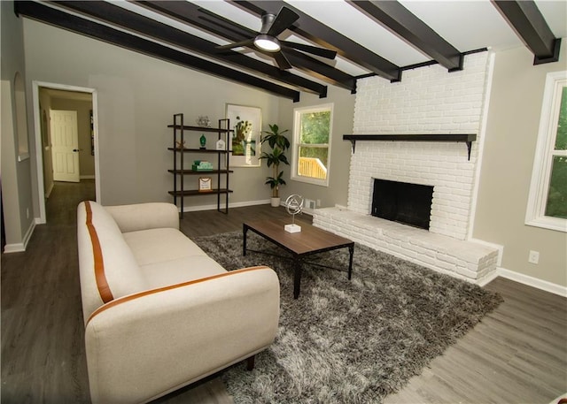 living room featuring a brick fireplace, dark hardwood / wood-style floors, vaulted ceiling with beams, and ceiling fan