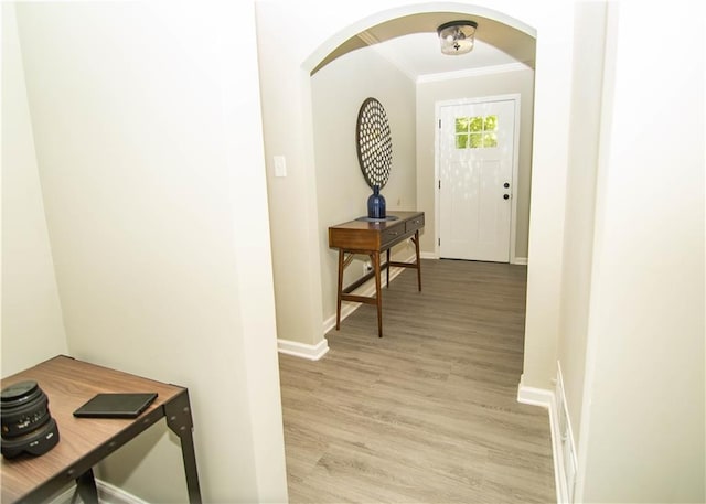 interior space with crown molding and light wood-type flooring