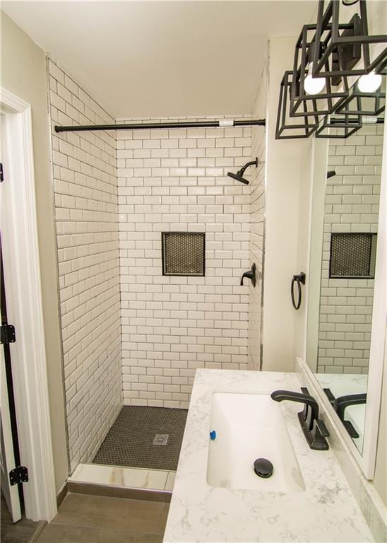 bathroom with vanity and a tile shower