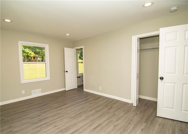 unfurnished bedroom featuring wood-type flooring and a closet