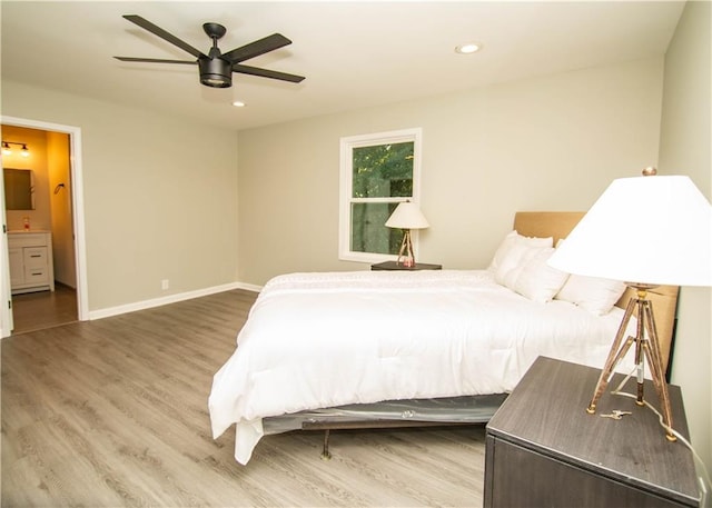 bedroom featuring connected bathroom, hardwood / wood-style flooring, and ceiling fan