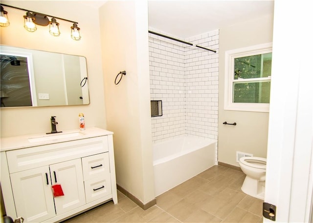 full bathroom featuring tiled shower / bath combo, vanity, and toilet