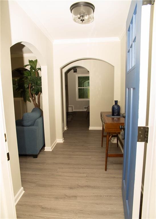 hall featuring crown molding and light hardwood / wood-style flooring